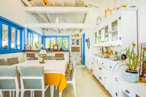 uma cozinha com armários azuis e brancos e uma mesa e cadeiras em VELINN Pousada Casa da Imperatriz em Ilhabela