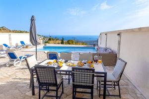 a dining table and chairs with a view of a pool at Luxury Villa Layla with private pool near Dubrovnik in Ivanica