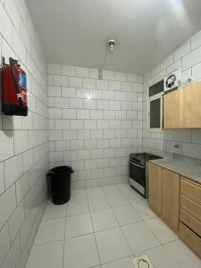 a kitchen with white tiled walls and a stove at أللورا زون - Alora Zone in Abha