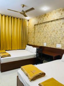 Un dormitorio con dos camas y un ventilador de techo. en Quality Comforts Guest House, en Bangalore