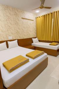 two beds in a room with yellow curtains at Quality Comforts Guest House in Bangalore +48 photos