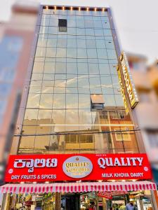 Un edificio alto con un cartel al costado. en Quality Comforts Guest House, en Bangalore 34 fotos más