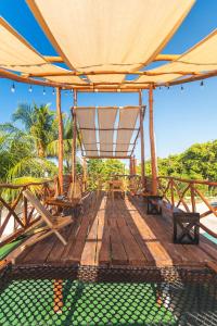 une terrasse en bois avec des chaises et un grand parasol dans l'établissement Casa Manglar Sisal by WoWay Experiences, à Sisal