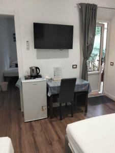 a room with a table and a television on the wall at Mimi family in Florence