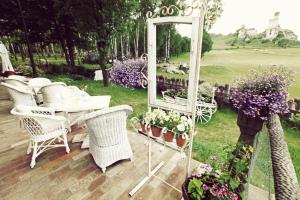 a mirror sitting on a deck with chairs and flowers at Zabytkowy Spichlerz w Olsztynie koło Częstochowy in Olsztyn