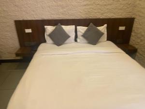 a bed with white sheets and pillows at Collection O Jodhpur Railway Junction Formerly Paro Niwas in Jodhpur +9 photos