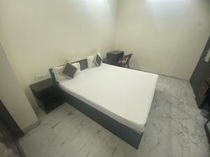 a bedroom with a bed with white sheets and pillows at Collection O Jodhpur Railway Junction Formerly Paro Niwas in Jodhpur