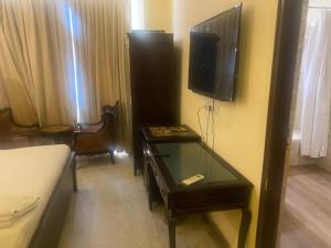a hotel room with a table and a tv on the wall at Collection O Jodhpur Railway Junction Formerly Paro Niwas in Jodhpur