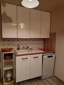 a kitchen with white cabinets and a sink at Bolquère appartement de plain-pied 1 à 4 personnes in Bolquere Pyrenees 2000 +3 photos
