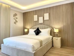 a bedroom with a large white bed with two lamps at Torri Studios in Sliema