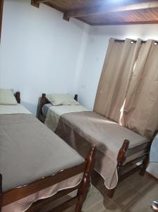 zwei Betten nebeneinander in einem Zimmer in der Unterkunft Cabaña Punta del Diablo in Punta Del Diablo + 10 Fotos