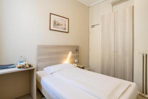 a small bedroom with a bed and a desk at Hotel Bazzoni in Tremezzo
