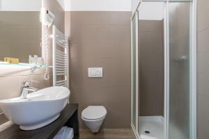 a bathroom with a toilet and a sink and a shower at Hotel Bazzoni in Tremezzo