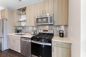 a kitchen with a stove and a microwave at Texas Two Step by 30A Escapes in Rosemary Beach