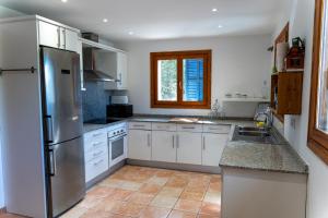 a kitchen with white cabinets and a stainless steel refrigerator at VILLA SOFIA in Valldemossa
