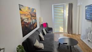 a living room with a couch and a painting on the wall at Citycentre - Sebastian in Budapest