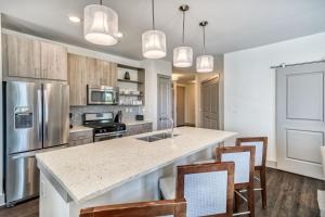 a kitchen with a large island with chairs and a counter top at The Pointe Unit 321 by 30A Escapes in Rosemary Beach +17 photos
