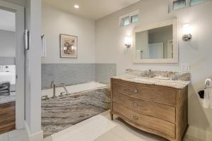a bathroom with a sink and a tub and a mirror at Walk to Ocean Luxe Family Home in Half Moon Bay! in Half Moon Bay +37 photos