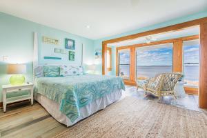a bedroom with a bed with a view of the ocean at Family Tradition - Duck, Sanderling, Soundfront, Private Pier, Sunset Views, Community Pool, Pets OK in Duck