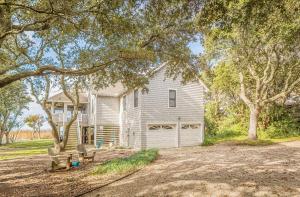 a white house with a tree and a driveway at Family Tradition - Duck, Sanderling, Soundfront, Private Pier, Sunset Views, Community Pool, Pets OK in Duck