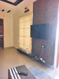 a living room with a flat screen tv on a wall at SK INN stays in Mahabalipuram +16 photos