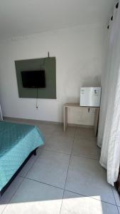une chambre avec un lit et une télévision sur un mur dans l'établissement Mirante LUZ FLORIPA, à Florianópolis