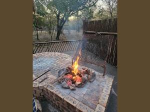 eine Feuerstelle im Hinterhof mit einem Zaun in der Unterkunft Kruger Boutique Backpackers in Marloth Park