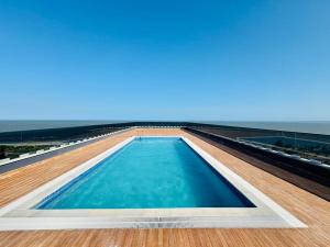 a swimming pool on top of a building with the ocean at Wanderlust Executive Stay in Maputo
