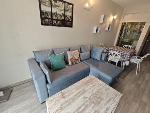 a living room with a blue couch and a table at New Gudauri GoodHost Apartments in Gudauri