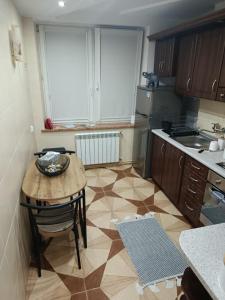 a kitchen with a small table and a kitchen with a sink at Apartament u Iwonki in Przemyśl