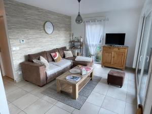 a living room with a couch and a coffee table at Bel appartement proche du lac in Duingt