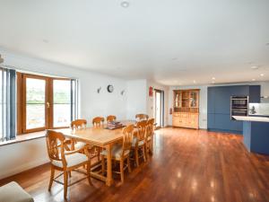 a kitchen and dining room with a wooden table and chairs at 4 Bed in Portreath 77719 in Portreath +16 photos