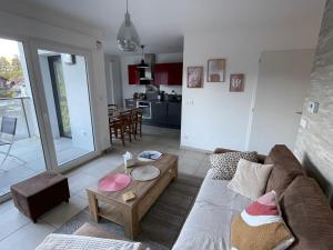 a living room with a couch and a table at Bel appartement proche du lac in Duingt
