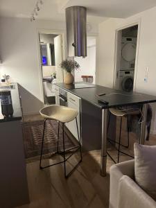 a kitchen with a counter and chairs in a room at Apartment for rent in Oslo