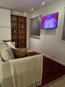 a living room with a couch and a tv on the wall at Apartment for rent in Oslo +7 photos