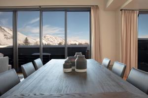 un tavolo da pranzo con sedie e una grande finestra di Town Hill Penthouse a Jackson