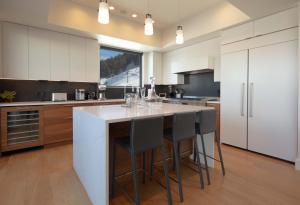 una cucina con isola bianca e sgabelli da bar di Town Hill Penthouse a Jackson
