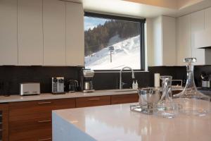 una cucina con una pista da sci vista attraverso una finestra di Town Hill Penthouse a Jackson