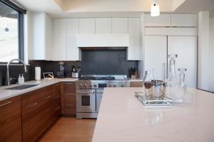 una cucina con mobili bianchi e un forno a piano cottura di Town Hill Penthouse a Jackson Altre 22 foto