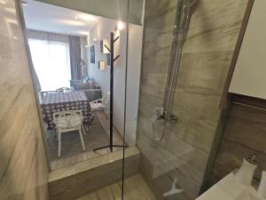 a bathroom with a shower with a table and a dining room at New Gudauri GoodHost Apartments in Gudauri
