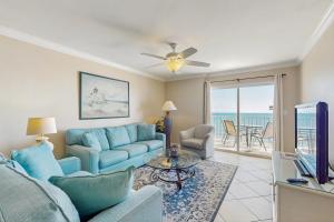 a living room with a blue couch and a tv at Ocean House II 2602 in Gulf Shores