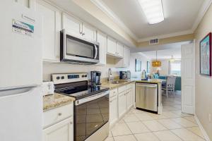 a kitchen with white cabinets and a microwave at Ocean House II 2602 in Gulf Shores