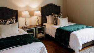 a hotel room with two beds and two lamps at 13 Olives, Entire Grape & Olive Estate, Somerset West by Euphoric Leisure in Sir Lowryʼs Pass +37 photos