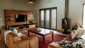 a living room with a couch and a coffee table at 13 Olives, Entire Grape & Olive Estate, Somerset West by Euphoric Leisure in Sir Lowryʼs Pass