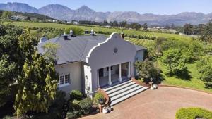 an aerial view of a house with mountains in the background at 13 Olives, Entire Grape & Olive Estate, Somerset West by Euphoric Leisure in Sir Lowryʼs Pass