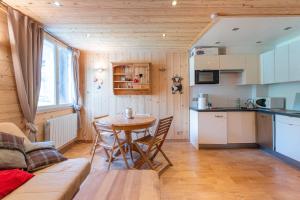 a living room with a table and a kitchen at Montjoie Appt centr pied des pistes in Saint-François-Longchamp