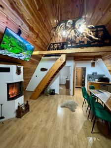 a room with a loft with a staircase and a tv at Cabana JagerBerg Rosenau in Râşnov