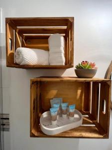a wooden cabinet with three cups and towels at Oceanfront Oasis - Panoramic Views & Marina Access in Beltran