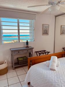a bedroom with a bed and a view of the ocean at Fajardo Oceanfront - Marina Views, Wi-Fi & Pool in Beltran