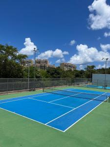 a tennis court with two tennis nets on it at Fajardo Oceanfront - Marina Views, Wi-Fi & Pool in Beltran